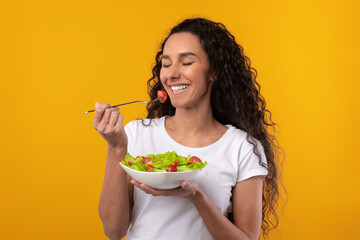 Wall Mural - Portrait of Smiling Latin Lady Holding Plate With Salad