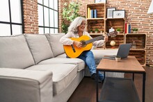 Middle Age Woman Having Online Guitar Class At Home