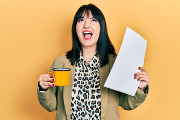 Sticker - Young hispanic woman wearing business style drinking cup of coffee angry and mad screaming frustrated and furious, shouting with anger looking up.