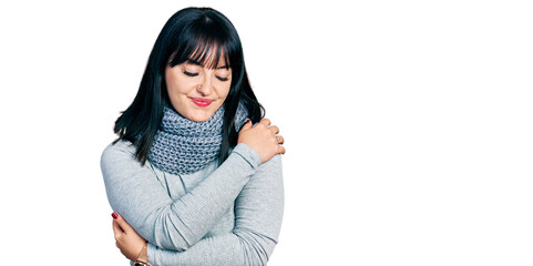 Poster - Young hispanic plus size woman wearing winter scarf hugging oneself happy and positive, smiling confident. self love and self care