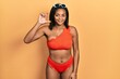 © Krakenimages.com - Young african american girl wearing bikini smiling and confident gesturing with hand doing small size sign with fingers looking and the camera. measure concept.
