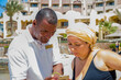 An Arab hotel employee shows something on the phone to a 40-year-old woman in a swimsuit on the beach.