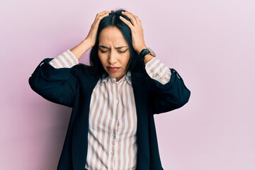 Wall Mural - Young hispanic girl wearing business clothes suffering from headache desperate and stressed because pain and migraine. hands on head.