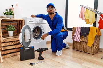 Poster - Young indian technician working on washing machine looking at the camera blowing a kiss on air being lovely and sexy. love expression.