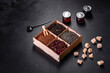 Several kinds of dry black tea with bergamot, rooibos, green and frame in a wooden box on a black concrete background