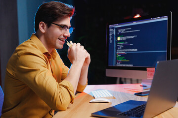 side profile view young site reliability engineer it specialist programmer man in shirt work at nigh