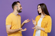 © ViDi Studio - Young smiling cheerful happy cool couple two friends family man woman together in yellow casual clothes look to each other speak talk spead hands isolated on plain violet background studio portrait.