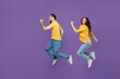 © ViDi Studio - Full body young excited cheerful fun overjoyed couple two friends family man woman together in yellow casual clothes jump high run fast hurry up isolated on plain violet background studio portrait