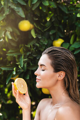 Wall Mural - Beautiful woman with smooth skin with a lemon fruit in her hands