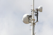 High Speaker With Two White Speakers, Warning System. Loudspeakers On A Pole Against A Cloudy Sky.