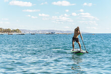Young Male Surfer Riding Standup Paddleboard In Ocean.