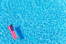 Inflatable Mattress With USA Flag Floating In The Pool