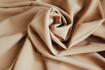 Beige fabric for drapery. A piece of matter with purple folds.
