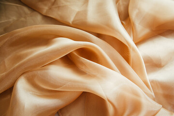 Golden fabric for drapery. A piece of cloth with folds. Crumpled Texture