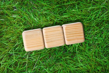 Poster - Three wooden cubes on green grass