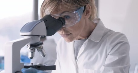 Wall Mural - a researcher examines a biological sample under a microscope.