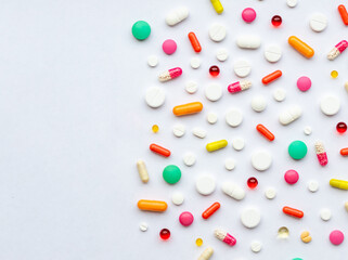 Creative layout of colorful pills and capsules on green background. Minimal medical concept. Pharmaceutical, Covid-19. Flat lay.Medication and prescription pills . Virus epidemic.