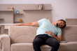 © Elnur - Young man sitting on the sofa
