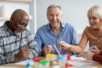 Cheerful pensioners attending art and craft class at sanatorium