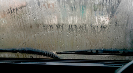 close-up view of sweaty car with dew all over windshield