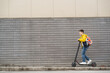 © Andrii  - Handsome teenager riding an electric scooter