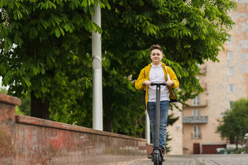 Wall Mural - Joyful teenager rides on electric scooter outdoor