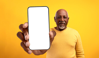 Great app. African american senior man showing big empty cellphone screen, recommending your ad, mockup
