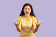 Angry ethnic woman isolated on purple studio background feel furious and enraged. Mad Latino girl scream and shout show rage and fury. Emotion control and temper concept.