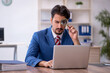 © Elnur - Young male employee working in the office