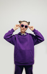 Wall Mural - Cute teen girl in a purple hoodie. Kids hoodies mockup. Studio shot on white background.