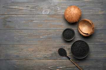 Wall Mural - Bowls with coconut activated carbon on dark wooden background