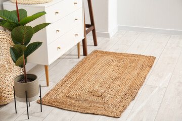 Wicker rug near chest of drawers in stylish room interior