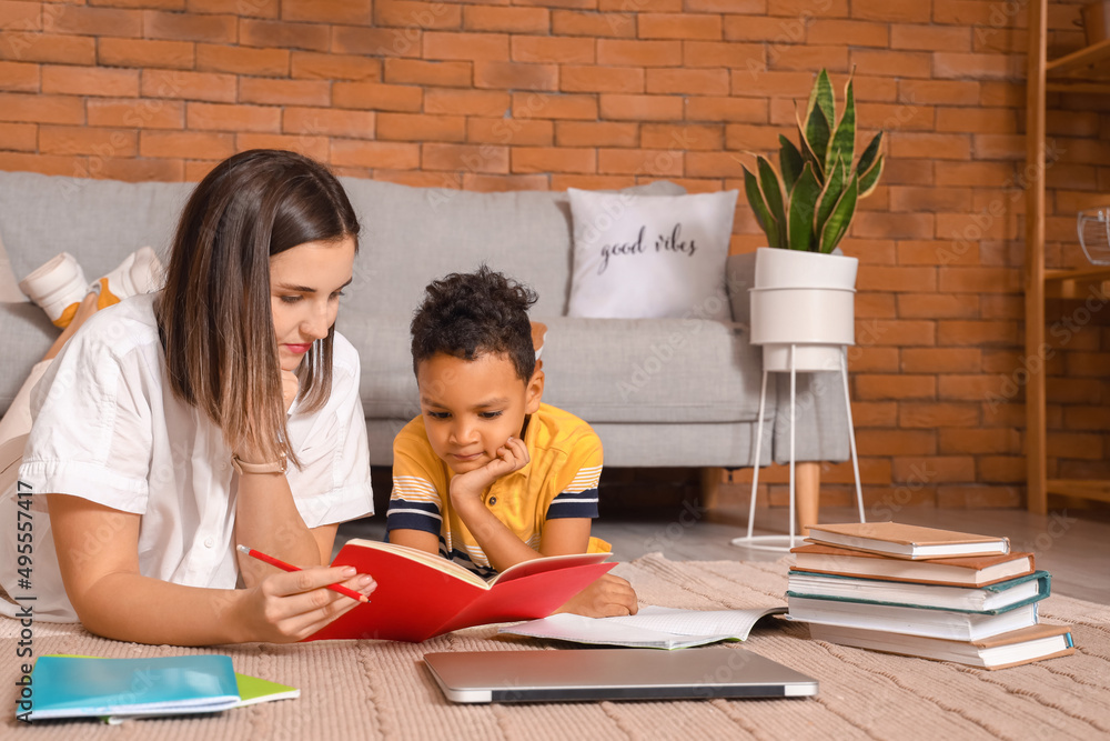 Little African-American boy studying with tutor at home