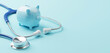 © Monster Ztudio - Top view of medical stethoscope and piggy bank on cyan background. Investment in health insurance and wealth concept. 3d rendering