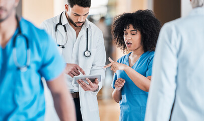 Canvas Print - Taking to telemedicine like the pros they are. Shot of two young doctors using a tablet and having a discussion in a modern office.