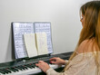 © Jose D´Alessandro - Young student girl playing piano with music sheet in home