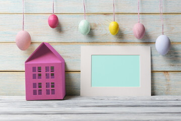 Wall Mural - Easter still life with house model, decorative eggs and blank card with copy space