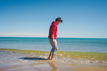 Young man walking near the sea