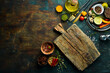 Leinwandbild Motiv Wooden board on a black stone table with vegetables and spices. Food background. Top view. Rustic style.