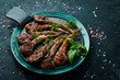 Roasted lamb chops on a dark creative restaurant background. Free copy space.