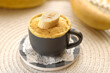 selective focus. cupcake in a mug with banana pieces. Banana cupcake on a light background. vanilla biscuit in a mug. The concept of a dessert in the microwave. bananas cake. High quality photo