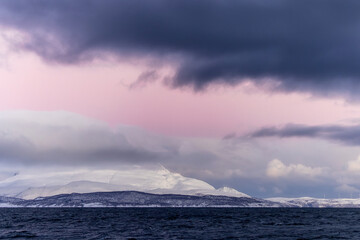 Sticker - Snowy landscape in the sea under the purple cloudy sky in Norway