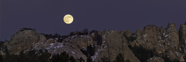 panoramic view of the full moon above the rocky mountains in custer, south dakota