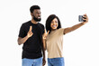 © F8  \ Suport Ukraine - Portrait of a two joyful young african couple taking a selfie isolated over white background