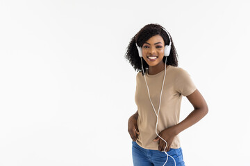 Poster - Young african woman wearing headphones dancing active isolated on white wall listening to music l