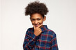 © Anatoliy Karlyuk - Crafty tricky boy in red and blue flannel shirt touching his chin planning joke at his friends or funny surprise, having dark skin and afro hairstyle, standing against white studio wall