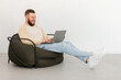 © Prostock-studio - Man Using Laptop Making Video Call Sitting Indoor, Side View