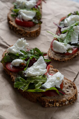 Sticker - Vertical shot of freshly baked country bread sandwiches with mozzarella, tomatoes and arugula