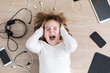 © ADDICTIVE STOCK - Screaming girl lying amidst gadgets