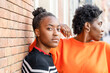 © ADDICTIVE STOCK - Serious black women near brick wall